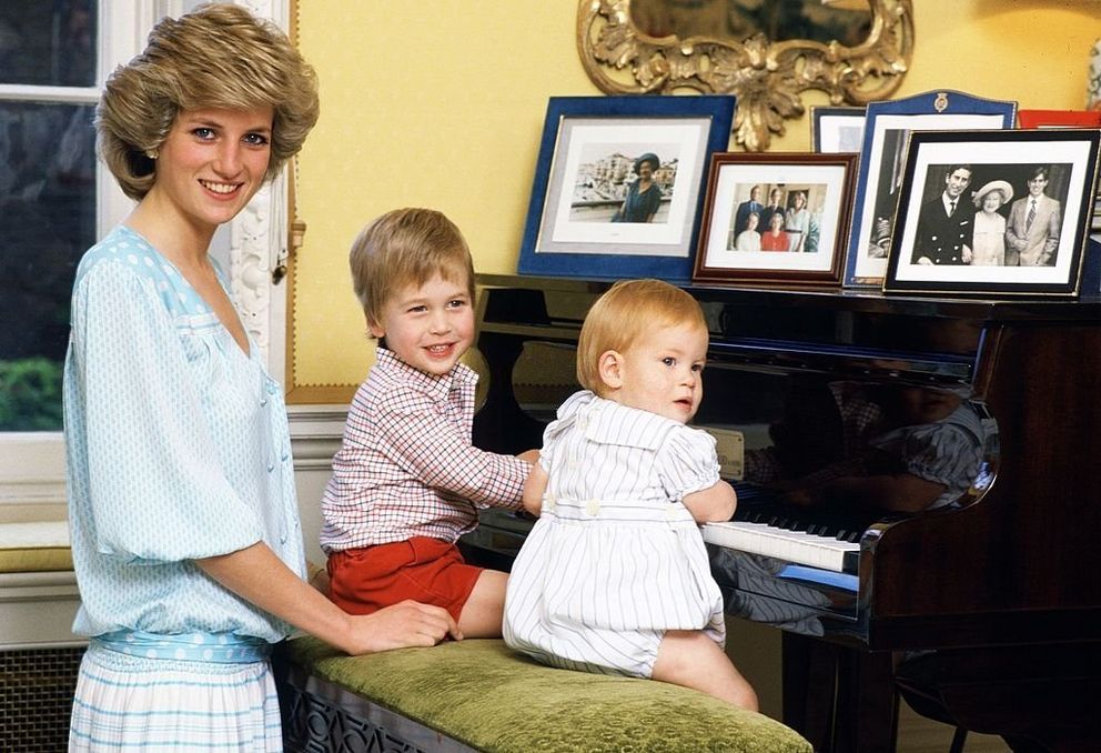 Diana, princesse de Galles, avec ses fils, le prince William et le prince Harry, au piano du palais de Kensington. | Photo : Getty Images