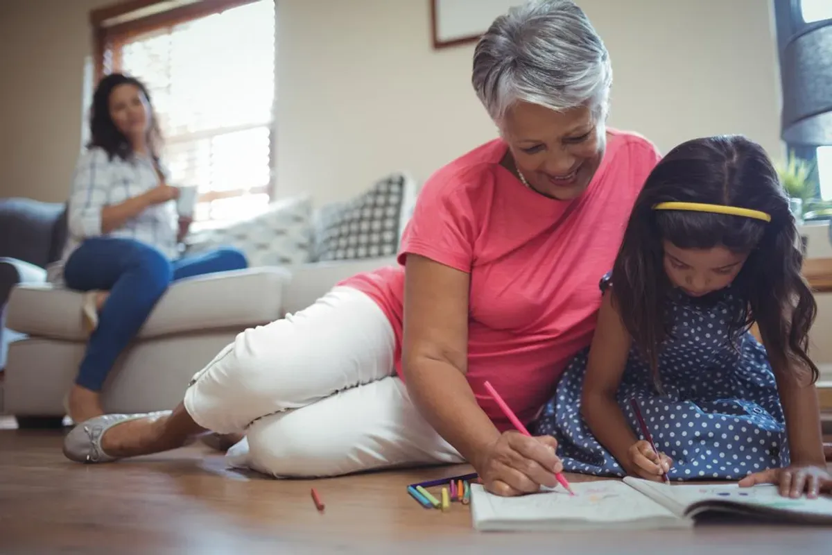 Grand-mère jouant avec sa petite-fille sur le sol. | Photo : Shutterstock