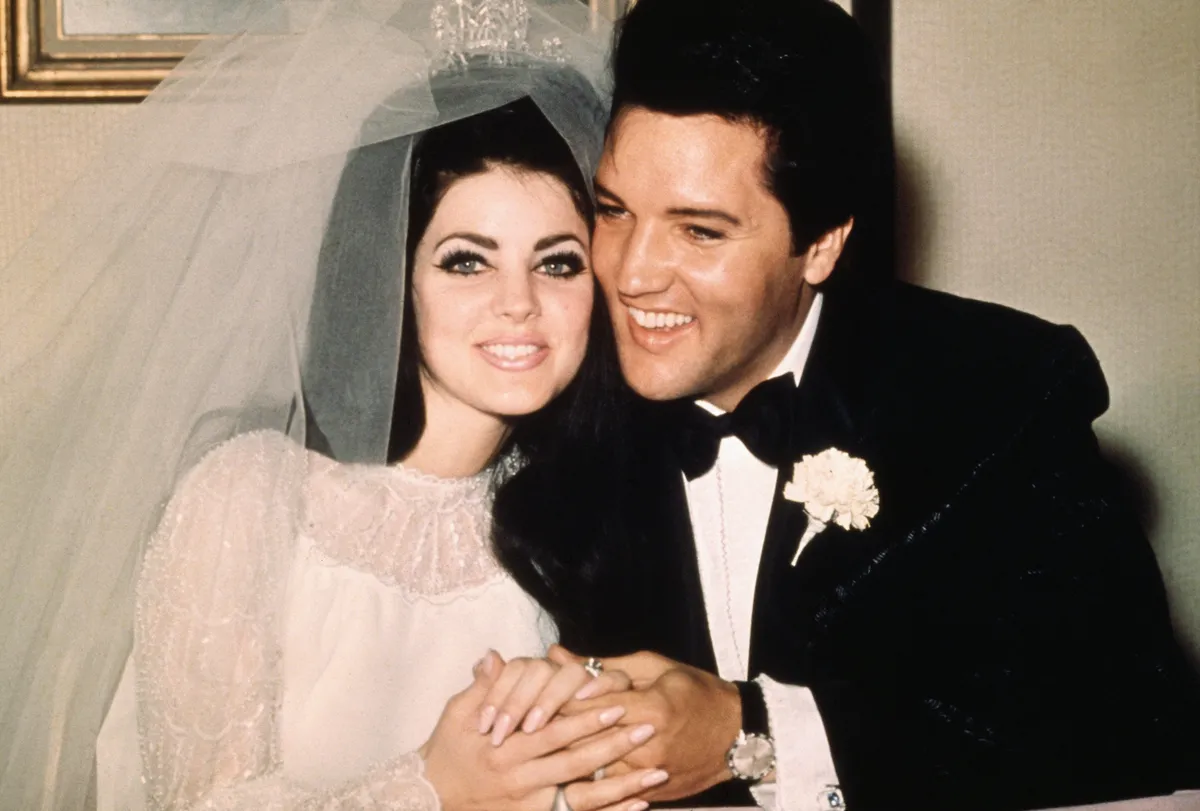 Elvis Presley sitzt mit seiner Braut, der ehemaligen Priscilla Ann Beaulieu, nach ihrer Hochzeit am 1. Mai 1967. | Quelle: Getty Images