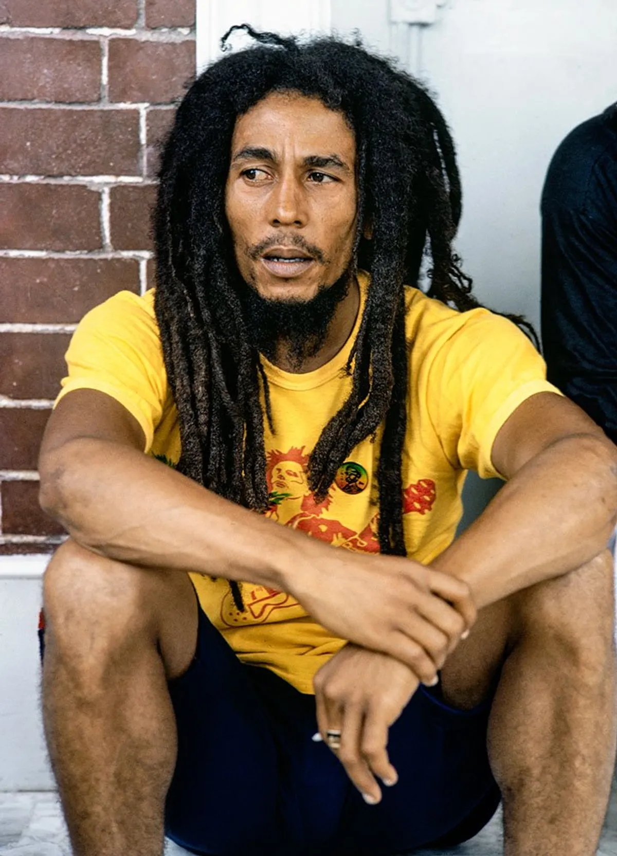 Bob Marley se détend avec des amis devant sa maison au 56 Hope Road le 9 juillet 1970 à Kingston, en Jamaïque. | Photo : Getty Images