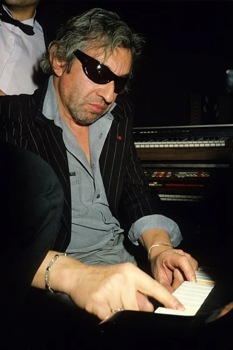 Serge Gainsbourg joue du piano au club Olivia Valere dans les années 1990, à Paris, France. | Photo : Getty Images
