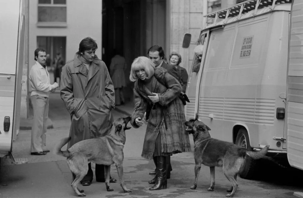 Alain Delon et Mireille Darc sur le tournage du film 'L'homme Pressé' réalisé par Edouard Molinaro en février 1977 à Paris, France. | Photo : Getty Images