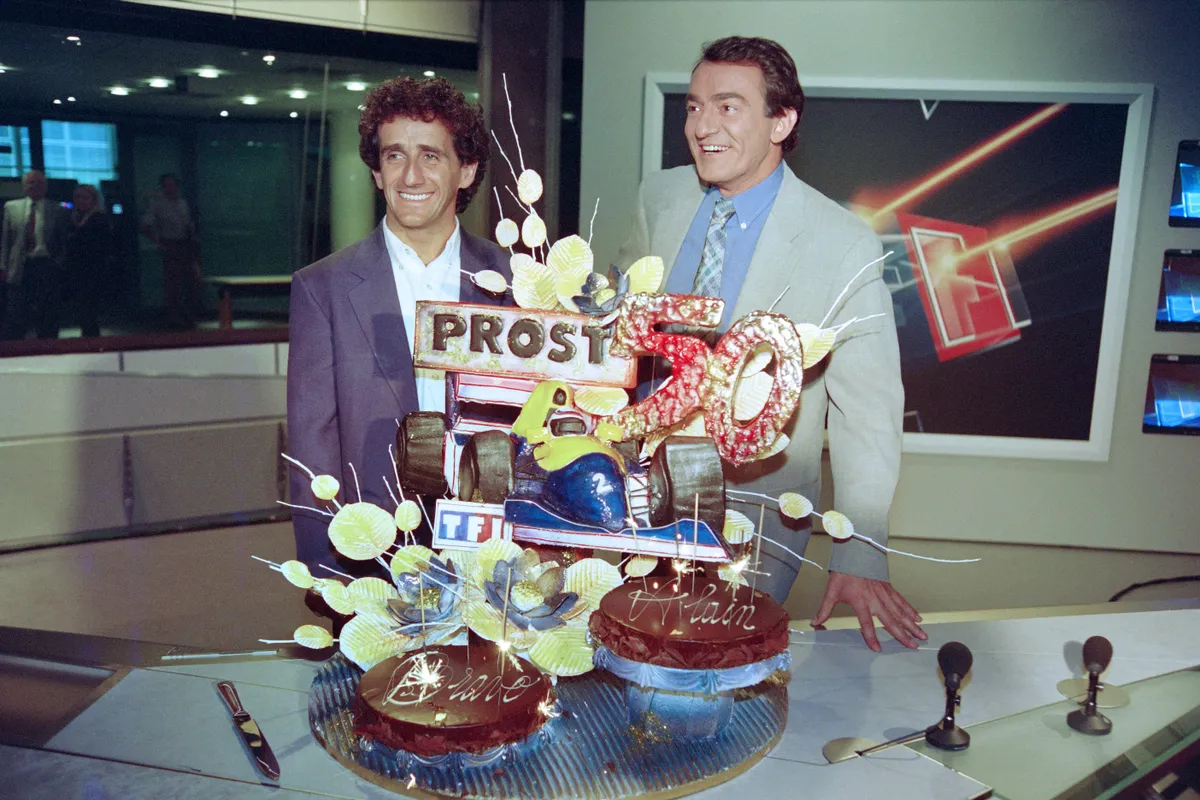 Le journaliste français Jean-pierre Pernaut (à droite) et le pilote français de Formule 1 Alain Prost célèbrent le 50e Grand Prix du champion de France après le journal télévisé diffusé par la chaîne de télévision française TF1 à Paris le 12 juillet 1993. | Photo : Getty Images